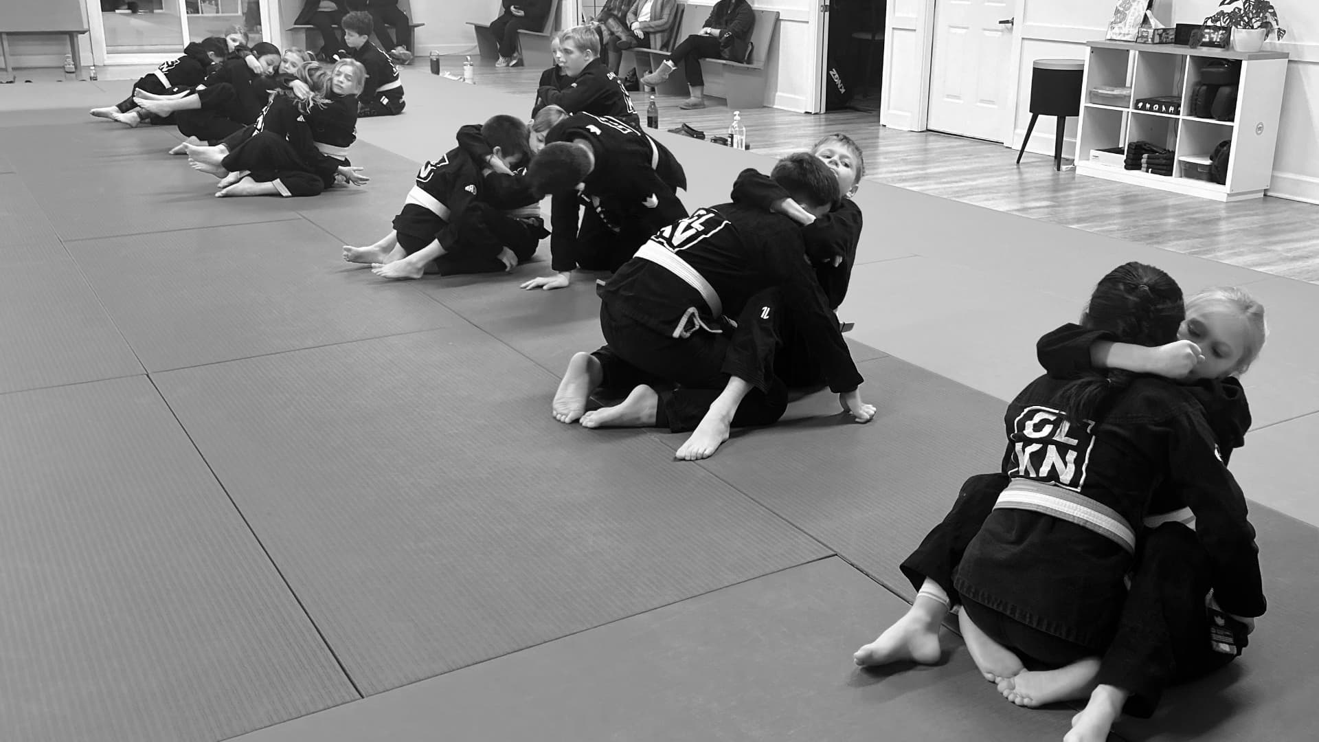 Junior Champions BJJ class with kids ages 8-11 practicing partner drilling techniques